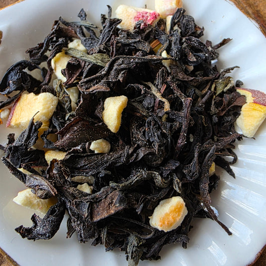 Dry tea leaves with pieces of peach fruit 